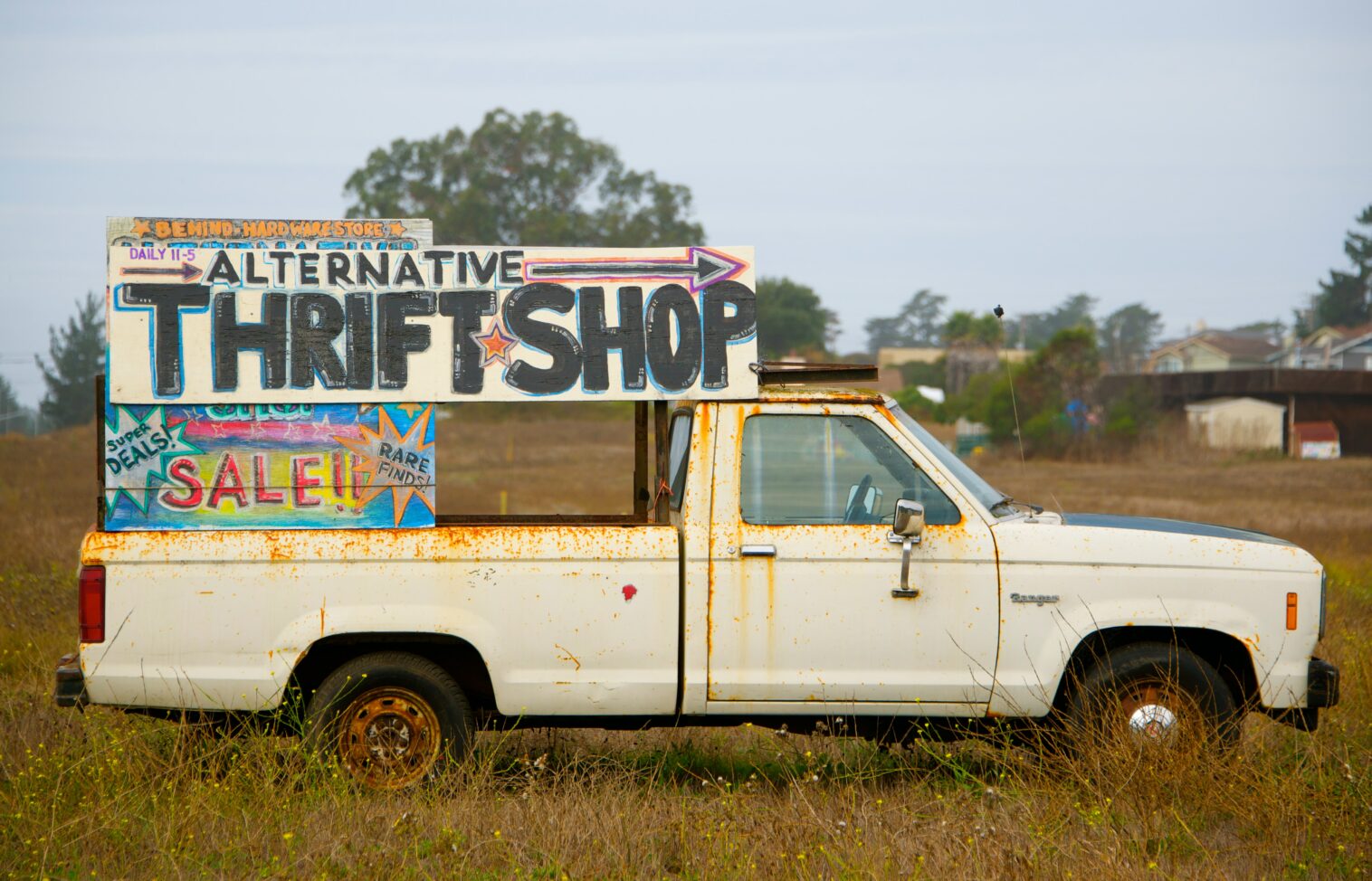 old white truck with thrifting sign in back