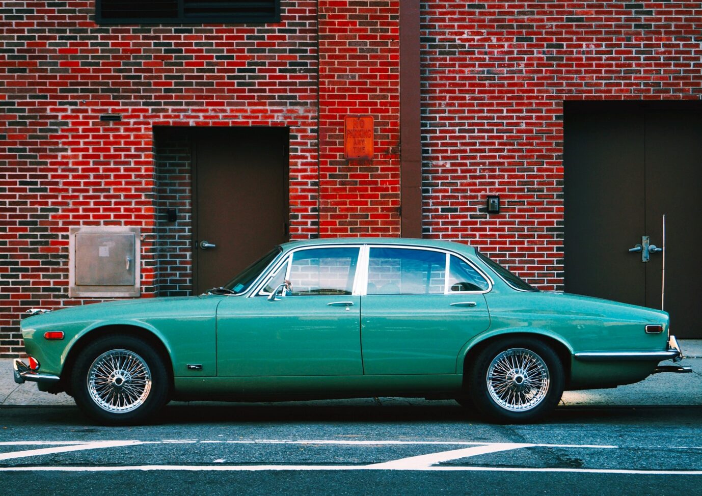 green vintage car in front of building