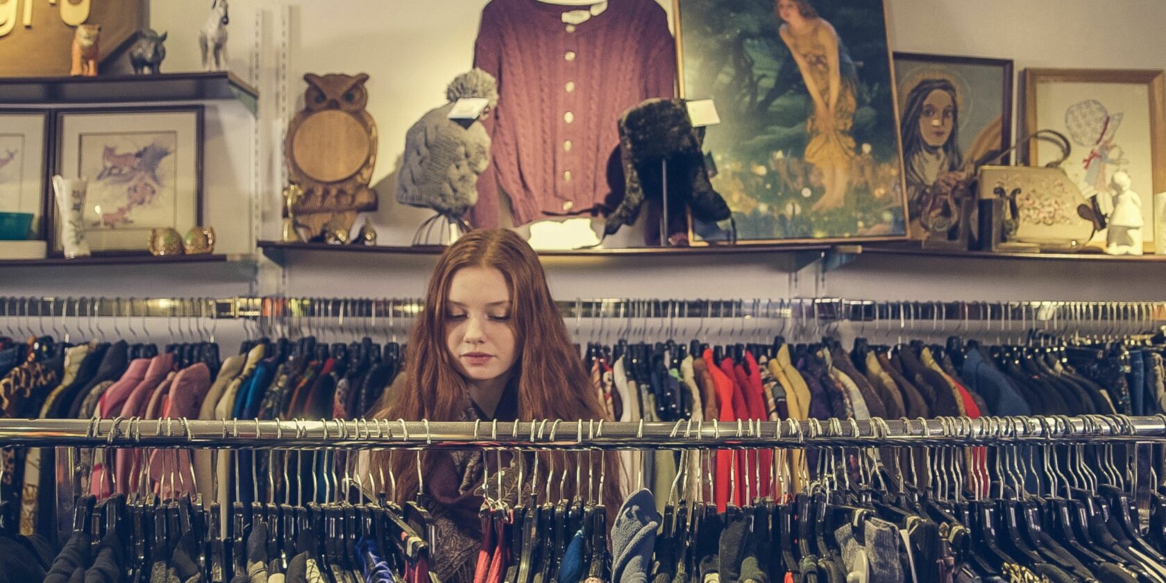girl looking through thrifted clothes
